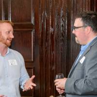 Two male alumni talk at event